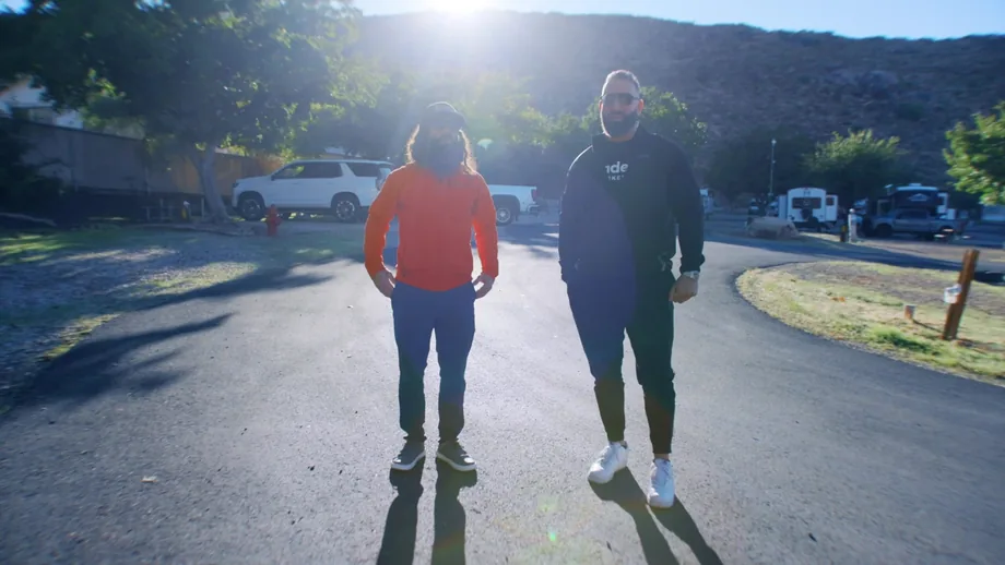 Two people filmed walking and talking on a residential street during a client video shoot