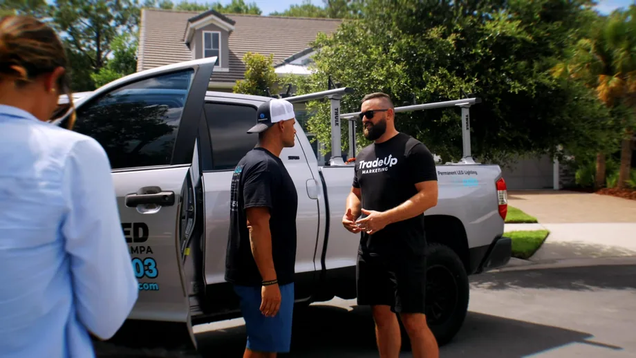 TradeUp Marketing team interviewing a roofing contractor beside his work truck