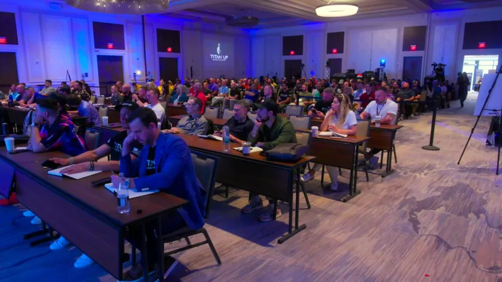 Conference attendees seated at tables in a hotel ballroom